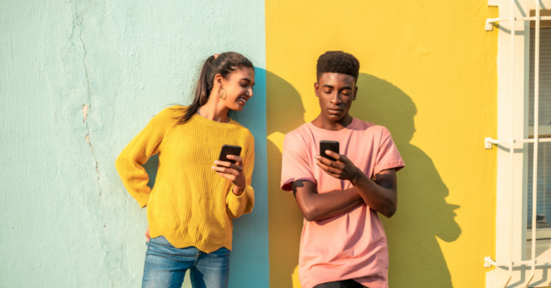 Zwei junge Menschen schauen auf ihre Handys
